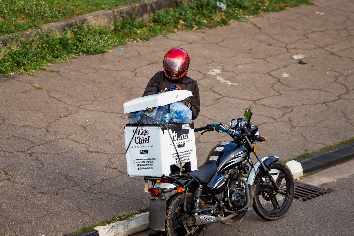 A delivery rider carrying a parcel in Nigeria